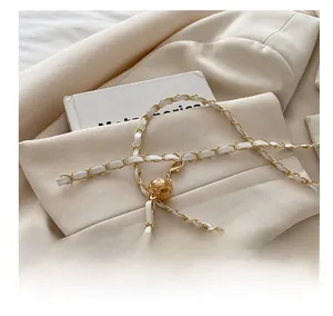 Detail of woven chain strap with diamond-patterned golden ball slider for adjustment