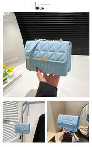Close-up of light blue quilted leather bag with elegant gold chain strap and metal lock
