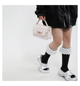 Detail of off-white crossbody bag with gold buckle styled in a trendy Y2K aesthetic look