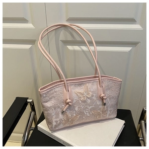 Detailed close-up of pink lace tote bag featuring 3D embroidered butterflies and knotted handle