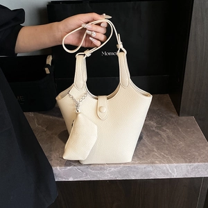 Chic beige bucket bag with litchi texture featuring a matching coin purse charm