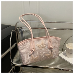 Detail of pink lace tote bag featuring 3D butterfly appliques and knotted handles