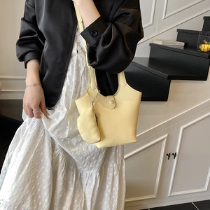 Fashionable pale yellow bucket handbag with matching mini coin purse and silver chain