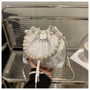 Close-up of white butterfly jacquard bucket bag with pearl handle and chain strap