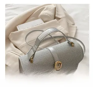 Detail of silver gray woven texture handbag with golden horsebit buckle handle