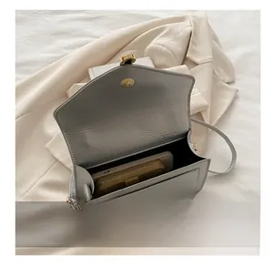 Interior capacity detail showing a smartphone and wallet inside the grey flap shoulder bag