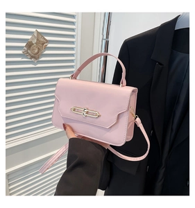 Detailed shot of pink leather handbag with luxury gold chain lock and shoulder strap