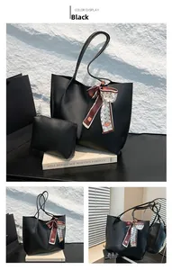 Détail rapproché du sac cabas noir tendance avec foulard en soie et petite pochette