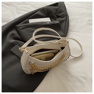 Close-up of white crocodile pattern shoulder bag showing interior phone and wallet storage