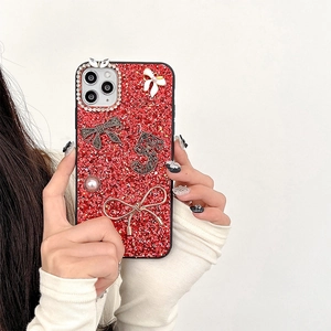 Detail of red glitter iPhone case with black bow, pearl accents, and rhinestone number 5