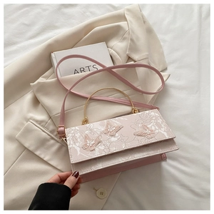 Close-up of pink crossbody bag with 3D butterfly embroidery and gold metal handle