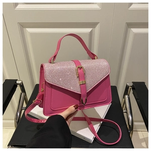 Detail of hot pink crossbody bag with shimmering rhinestones and golden hardware