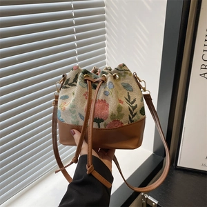 Vintage floral jacquard drawstring bucket bag with brown leather base and strap