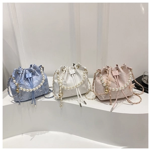 Detailed view of floral textured bucket bags with luxury pearl handles and chain straps