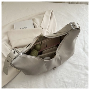 Detailed interior of a beige half-moon crossbody bag showing large capacity for essentials