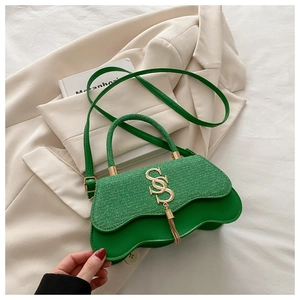 Détail macro d'un sac à main tissé vert avec bords ondulés et boucle dorée en S