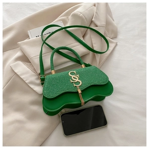 Détail du sac à main en tweed vert avec bords ondulés et boucle métallique dorée