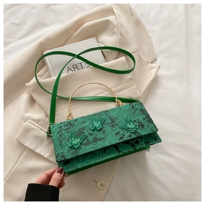 Close-up of emerald green crossbody bag featuring 3D butterfly embroidery and metal handle