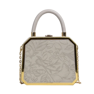 Hexagonal white evening clutch featuring floral embossing and gold-tone metal frame
