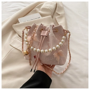 Detailed shot of pink lace bucket bag with pearl handle and 3D butterfly embroidery