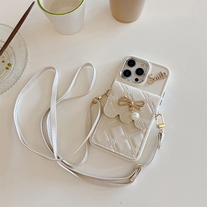 Dettaglio custodia iPhone in pelle trapuntata bianca con fiocco di perle e tracolla