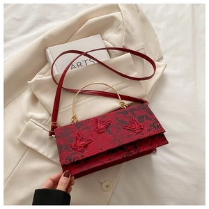 Detail of red floral lace embroidery and 3D butterfly appliques on small square bag