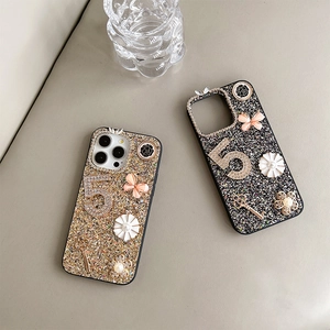 Detailed view of glitter iPhone case with butterfly and rhinestone key decorations.
