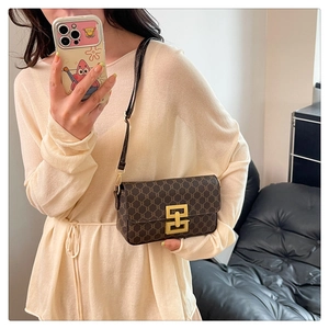 Detailed view of vintage monogram shoulder bag with matte gold buckle worn by model