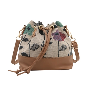 Ethnic embroidery drawstring bucket bag with brown leather base and adjustable strap