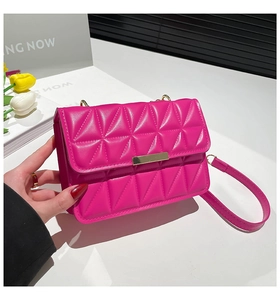 Close-up of pink quilted crossbody bag with gold metal clasp and elegant tulip decor