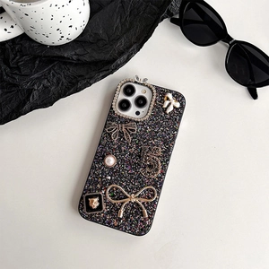 Detail of luxury iPhone case featuring glitter, rhinestones, pearls and golden charms