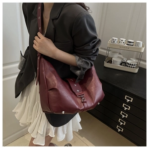 Side view of dark red vintage hobo bag featuring star rivets and adjustable strap