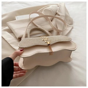 Détail du sac beige avec rabat ondulé, paillettes dorées et logo CD métallique