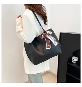 Grand sac fourre-tout noir minimaliste avec foulard en soie porté par un mannequin