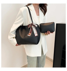 Grand sac cabas noir avec foulard en soie décoratif et petite pochette assortie.