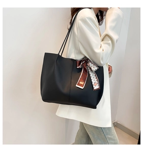 Détail d'un grand sac cabas noir avec une écharpe décorative en soie à motifs