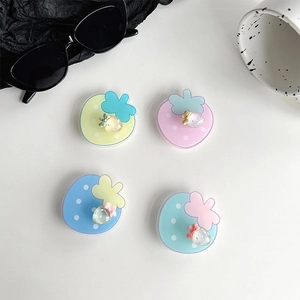 Close-up of four colorful strawberry phone grip stands in macaque pastel colors