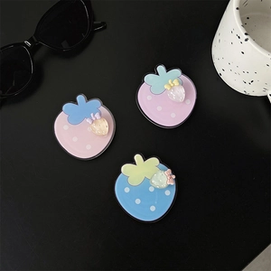 Detailed view of colorful strawberry phone grips in pink, purple and blue acrylic