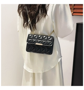 Detail showing the quilted texture and golden chain strap of the black shoulder bag