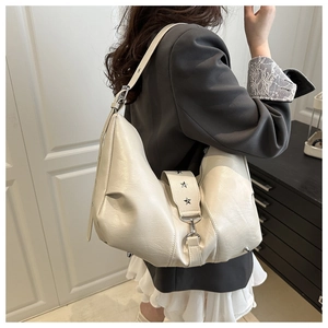 Detail of cream white hobo bag showing star rivet and soft textured faux leather