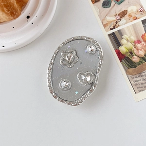 Détail du support téléphone argenté avec strass élégants en cristal et décor floral