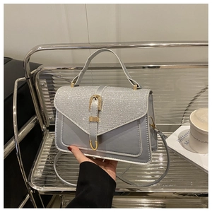 Detail of light blue sequined flap and gold buckle on a retro square crossbody bag
