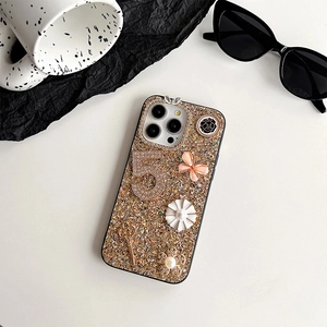 Detailed view of luxury gold glitter iPhone case with butterfly and rhinestone charms