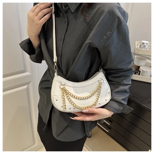 Close-up of white croc-embossed crescent shoulder bag with gold chain and thin strap