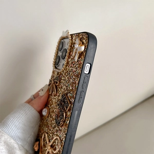 Detail of iPhone case with glitter sequins, white bow, pearls and rhinestone decorations