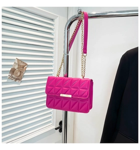 Detail of rose pink quilted crossbody bag with gold chain strap and metal clasp