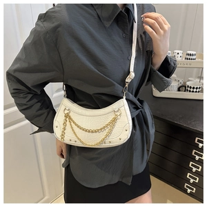 Detail of white crocodile pattern crescent bag with dual gold chain and silver rivets