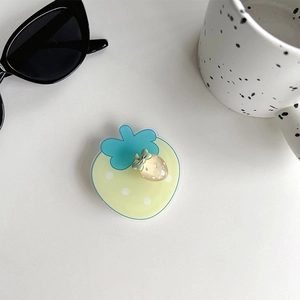 Detail of a rotating strawberry phone grip with yellow dots and cute blue leaf accent