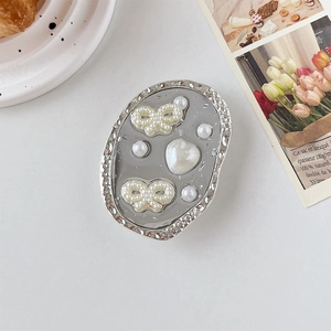 Détail du support téléphone avec papillon en perles et cœur au style rétro français