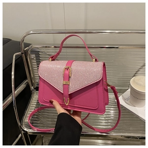 Macro shot of rose pink handbag featuring sparkly rhinestone flap and gold buckle